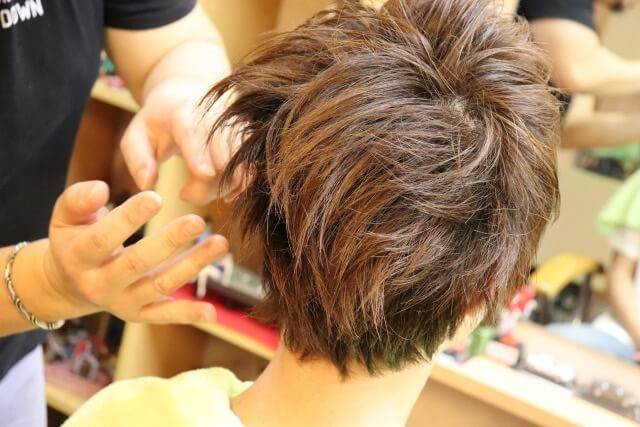 男性の髪を整髪している様子