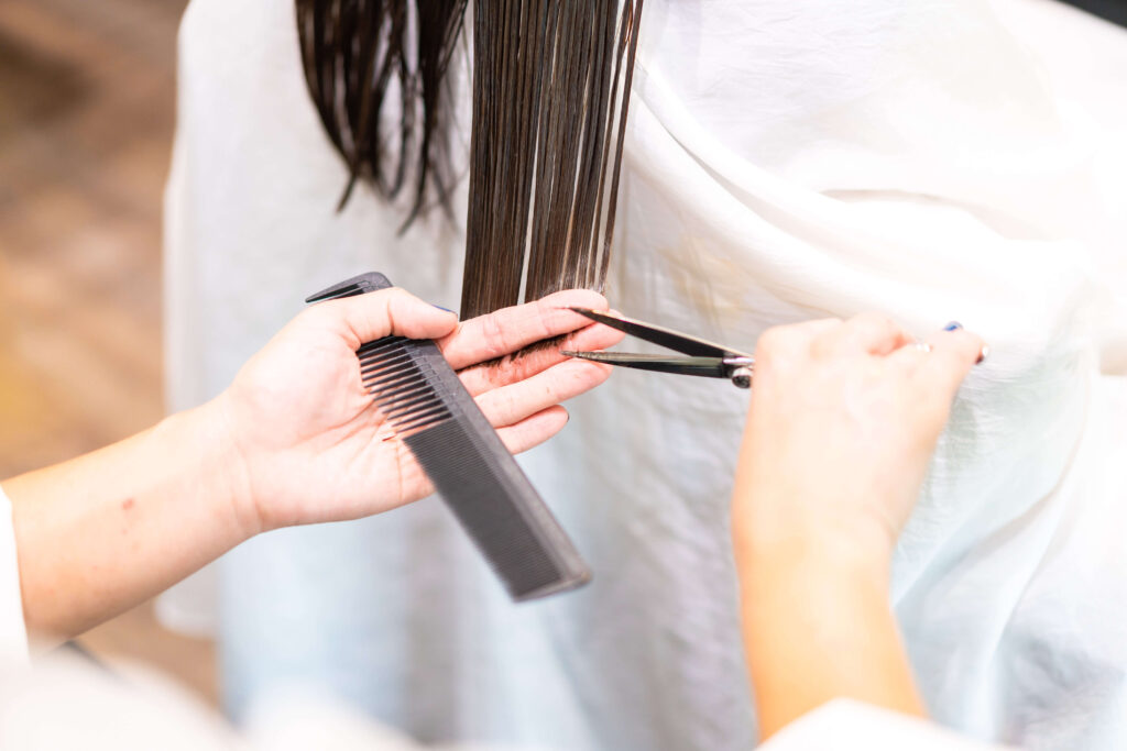女性の毛先をカットしている様子